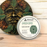 Solid lotion bar packaging with 'Green Man' design on a wooden surface green man solid lotion bar by brigid trading company beeswax shea butter and mango butter solid lotion bar natural ingredients raw oils olive sunflower jojoba almond handmade in small batches made in the usa manufactured in america washington state usa